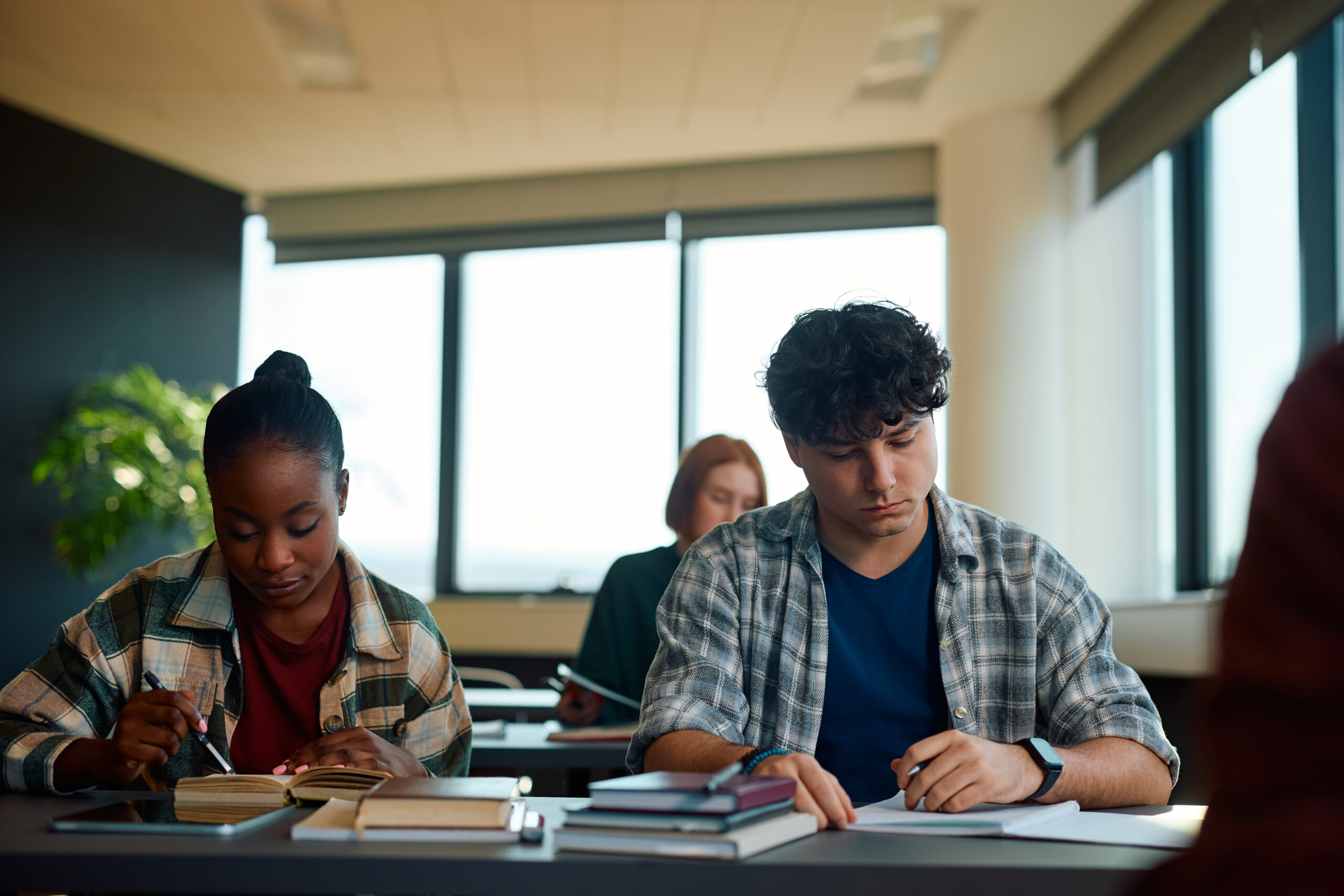 Adult students studying while attending at lecture in the classroom.
