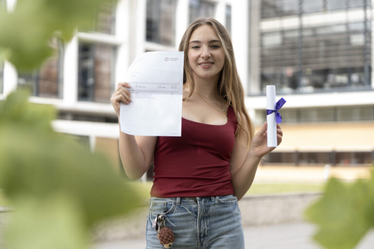 Eden Milner holding her results smiling