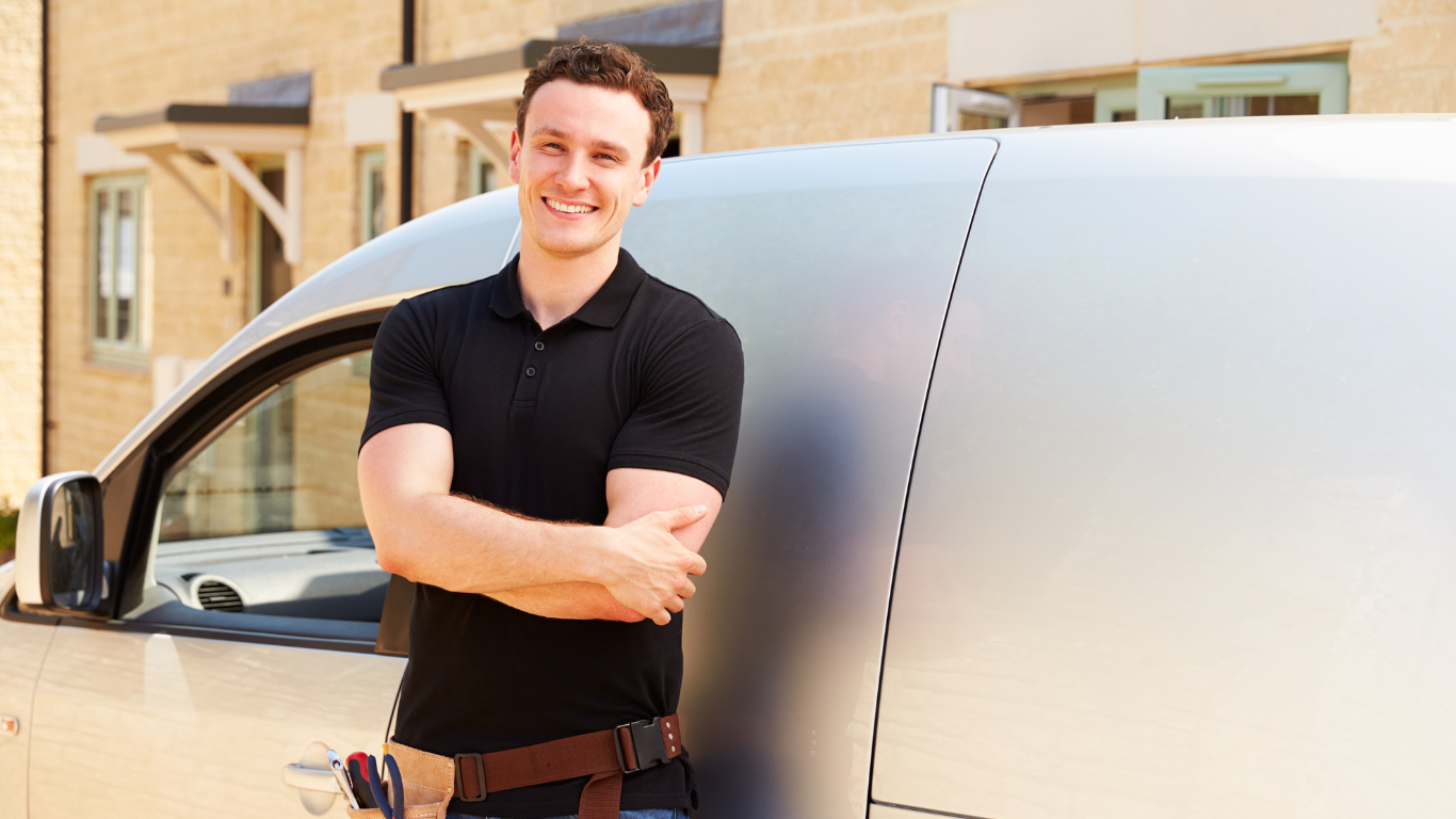 tradesman stood in front of white van